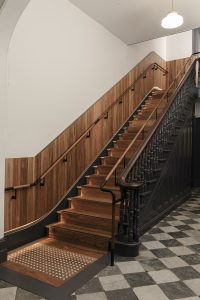 Warm timber staircase with checkerboard flooring and dark wooden handrail and details — heritage restoration — Ballarat — Moloney Architects
